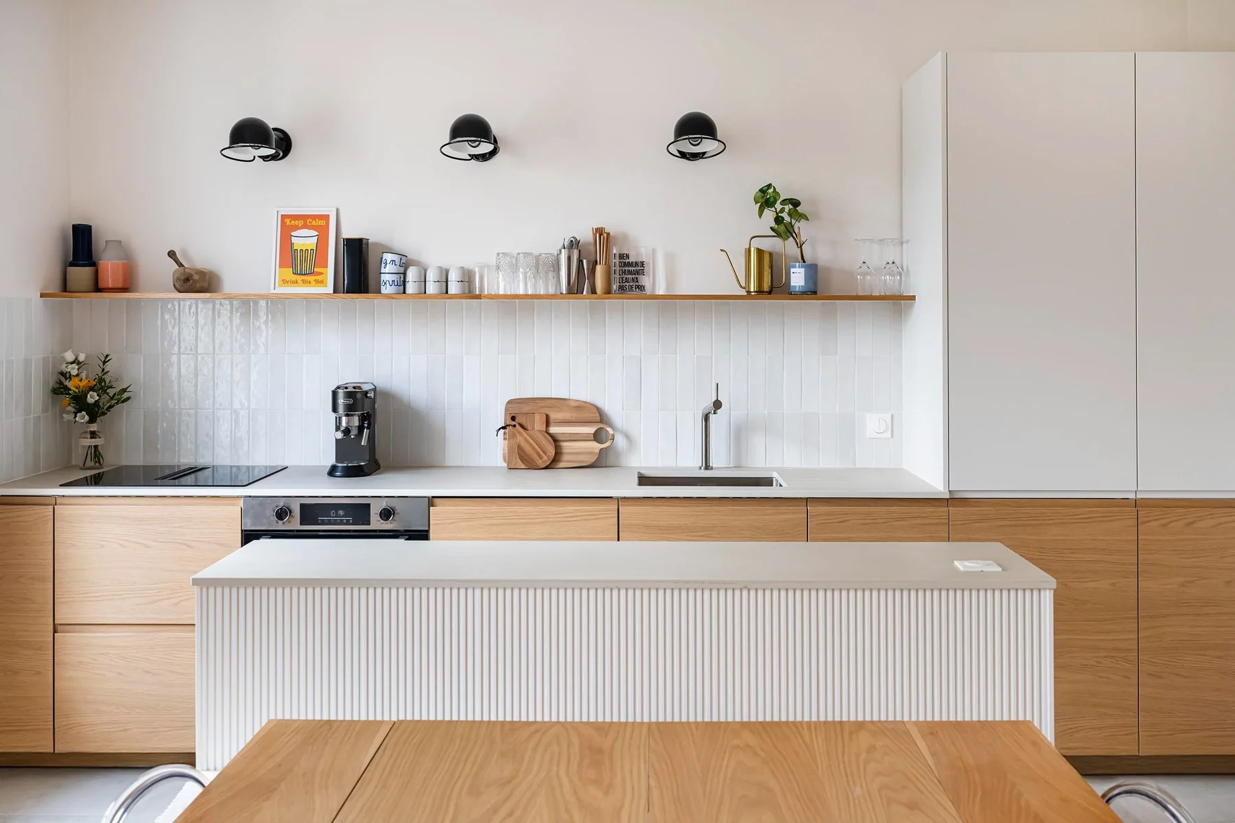 Cuisine ouverte avec îlot rainuré et façades en bois clair, projet Bécon à Asnières-sur-Seine