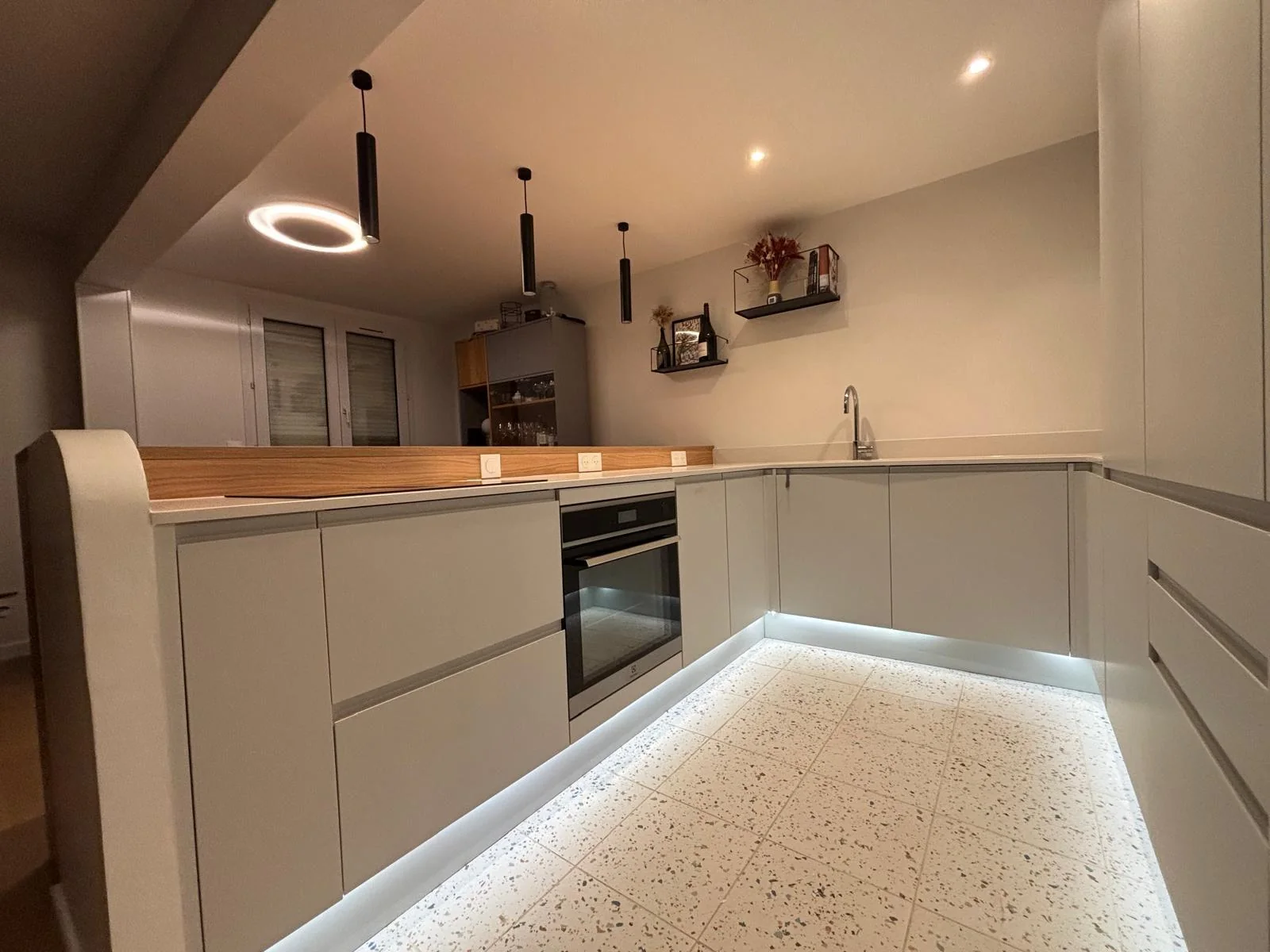 Cuisine en L aux façades grises avec éclairage LED